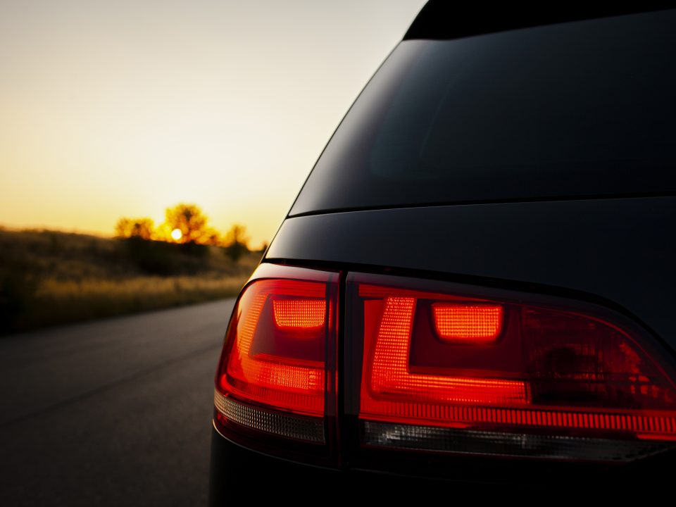 Os Impactos da Exposição ao Sol na Pintura do Carro luz traseira vermelha no fundo do por do sol